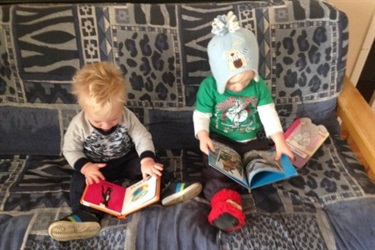 Two children reading on lounge