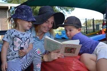 Educator reading to two children