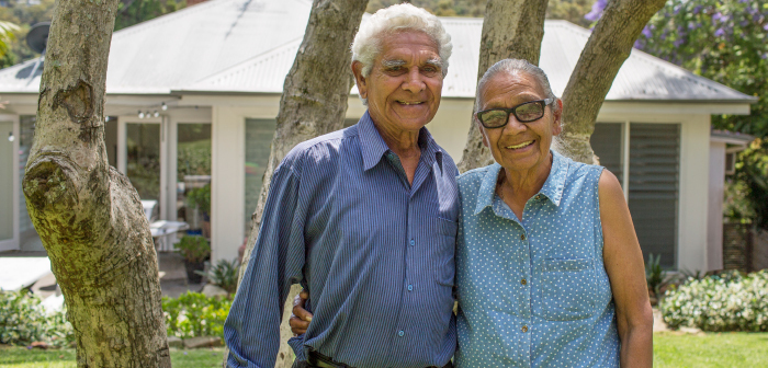 A couple smiling and looking at the camera