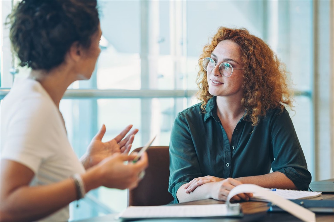 Two people discussing business papers