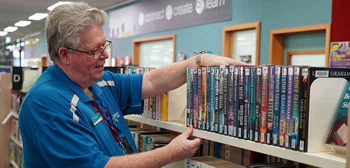 A library staff member looking at books on a shelf