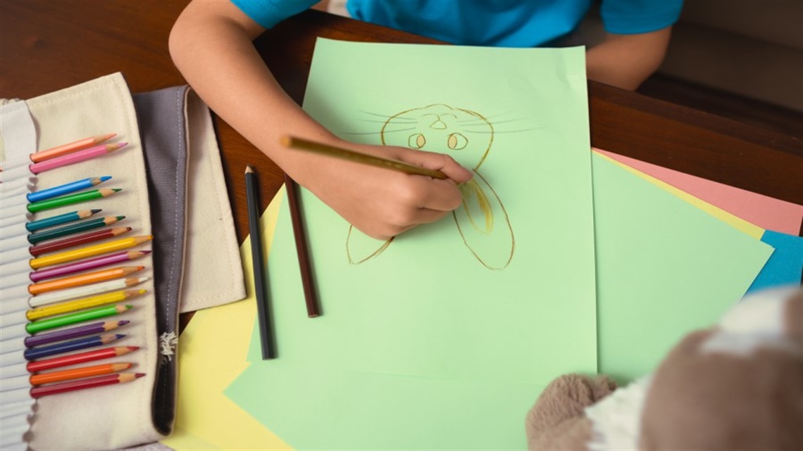 Child drawing with pencils