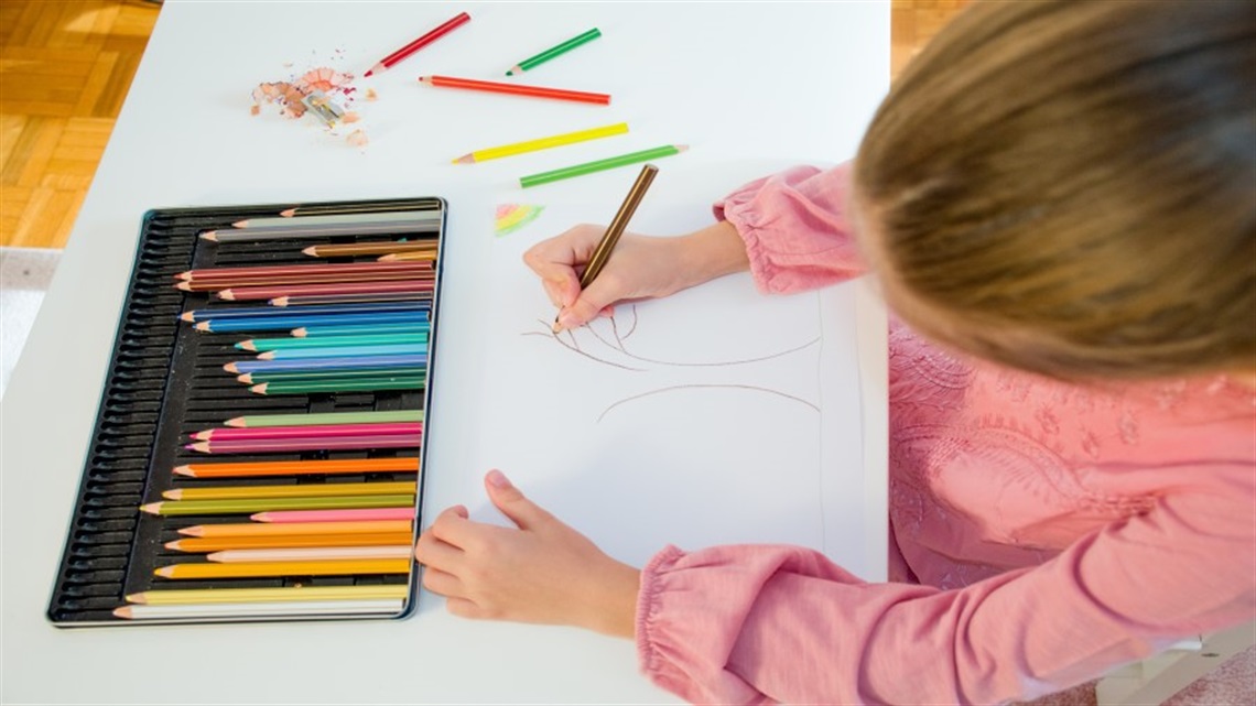 Girl drawing with pencils