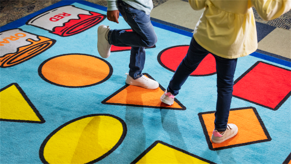 Kids stepping on colourful mat