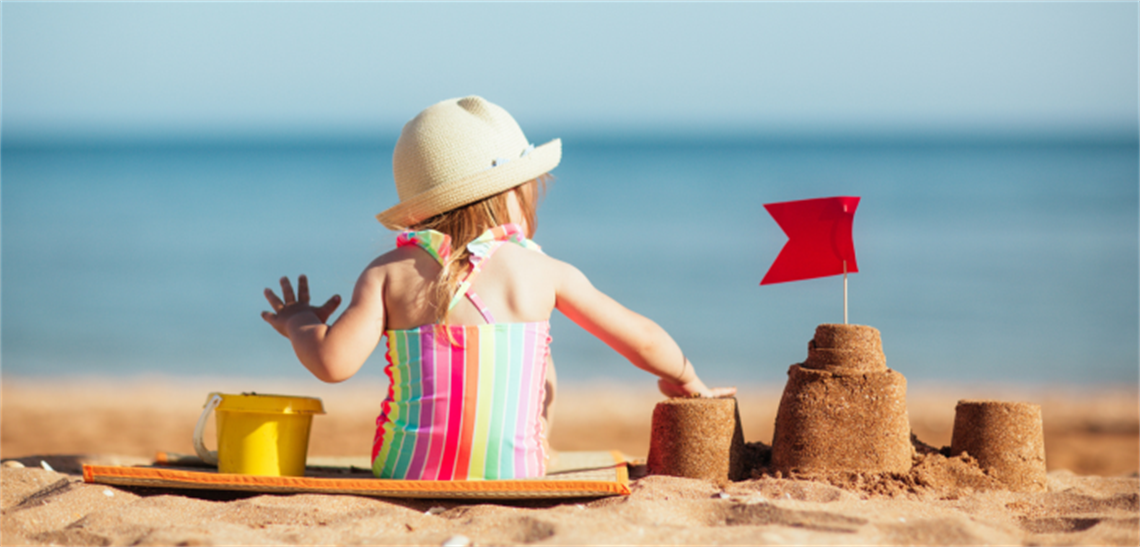 Girl building sand castle at beach