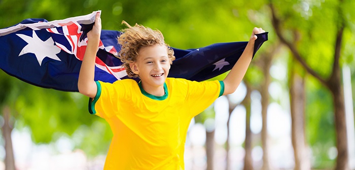 A boy running while holding the Australian flag