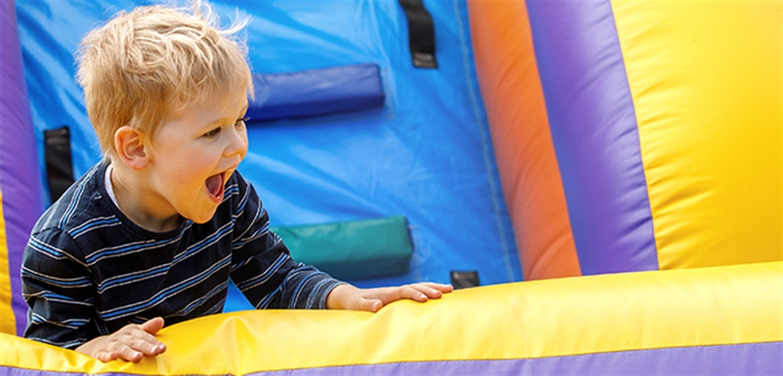 Young boy playing on an inflatable slide